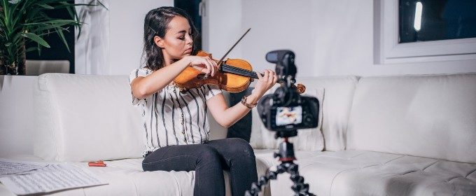 woman playing violin in front of camera